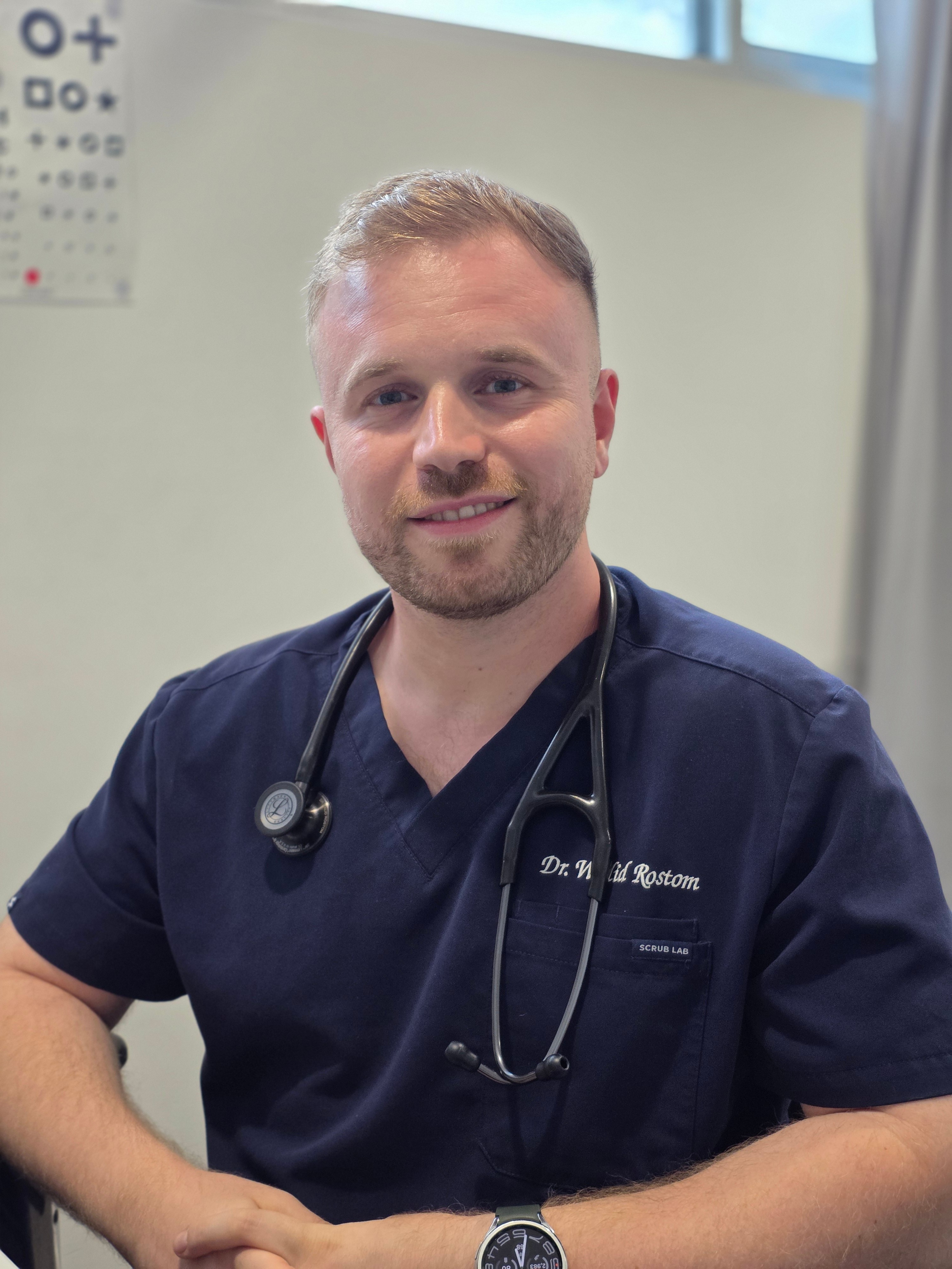 Stylized blue duotone portrait of a person facing the camera with arms crossed